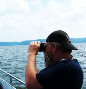 Todd Roll uses binoculars to search for Pepie the Lake Monster